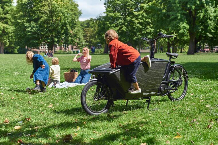 En familj i en park med en lådcykel från Urban Arrow